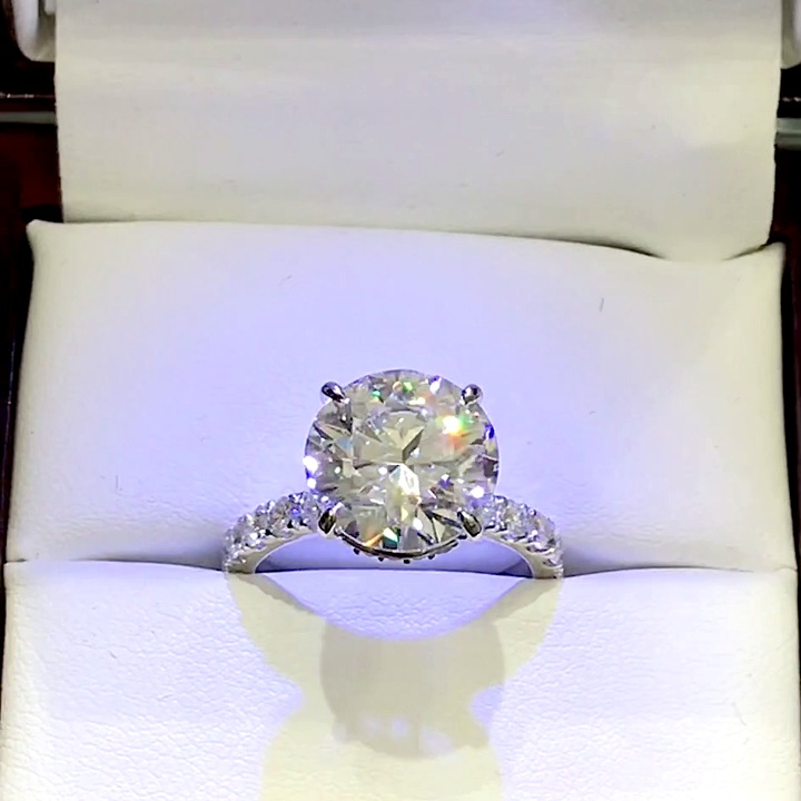 18kt White Gold Engagement Ring with 4.1 carats lab diamond at the center (Color: E | Clarity: VS1 | Round Cut) and natural E / VVS grade Setting Diamonds. Hidden Halo setting with diamonds on the shank.